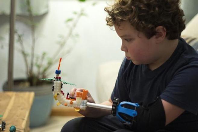 Foto de Aidan Robinson que ha creado, a sus 9 años, una prótesis con piezas de lego útil para desarrollar todo tipo de actividades 